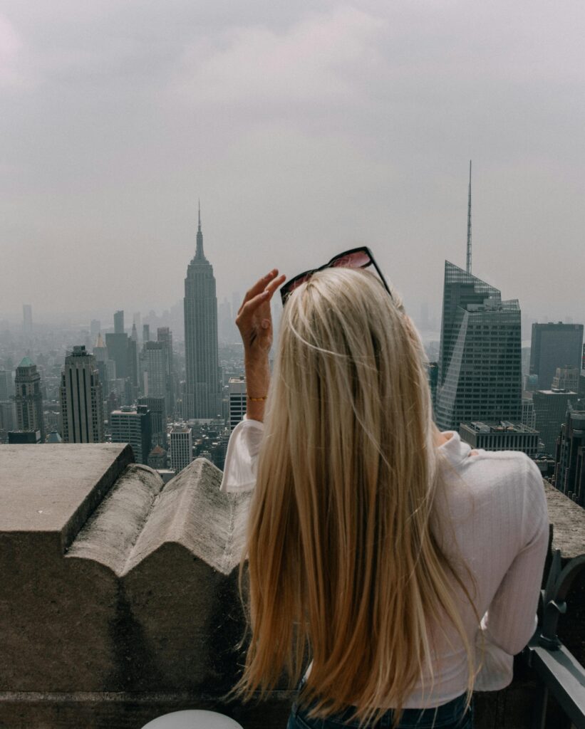 Woman stood on a roof top overlooking a city landscape