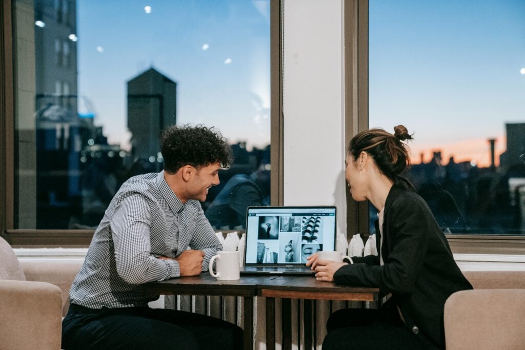 Two people checking through Images on a laptop