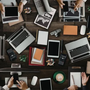 Overhead view of busy workspace with digital devices